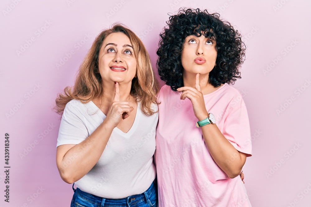 Middle east mother and daughter wearing casual clothes thinking concentrated about doubt with finger on chin and looking up wondering Middle east mother and daughter wearing casual clothes thinking concentrated about doubt with finger on chin and looking up wondering