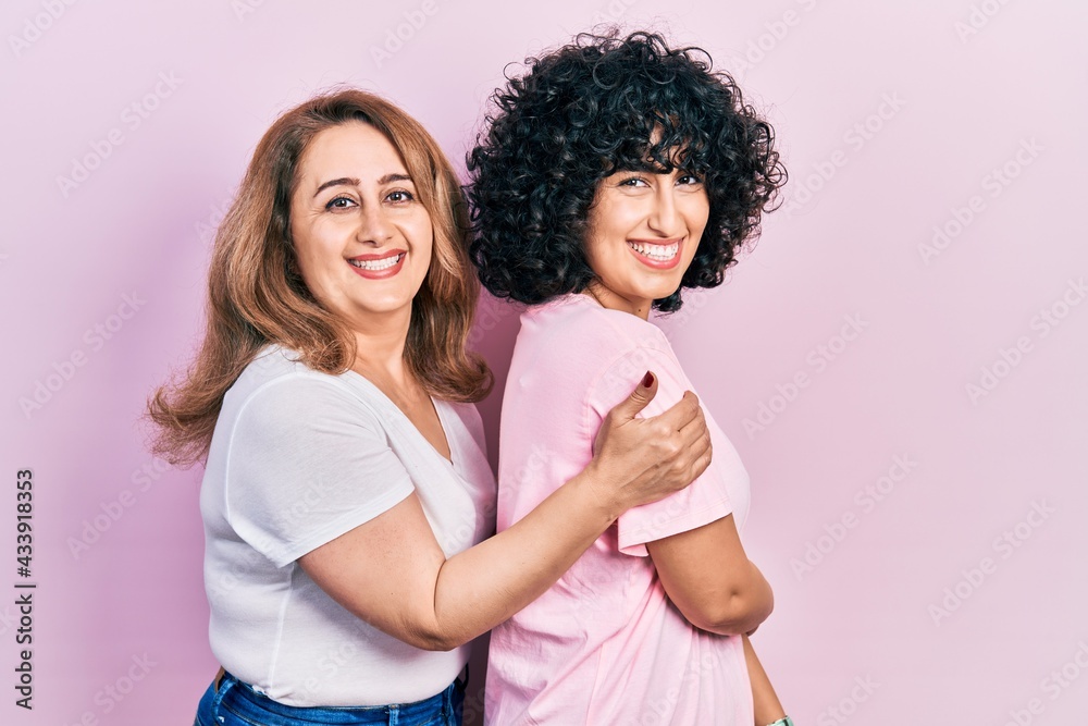 Middle east mother and daughter wearing casual clothes looking to side, relax profile pose with natural face and confident smile.