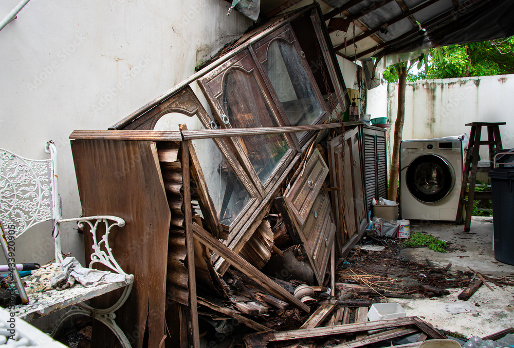 Hoarding disorder stay home in abandoned unorganized kitchen messy with broken ruined wooden old vintage antique cupboard collapse cabinets unhygienic glasses and dishes, dirty laundry washing machine