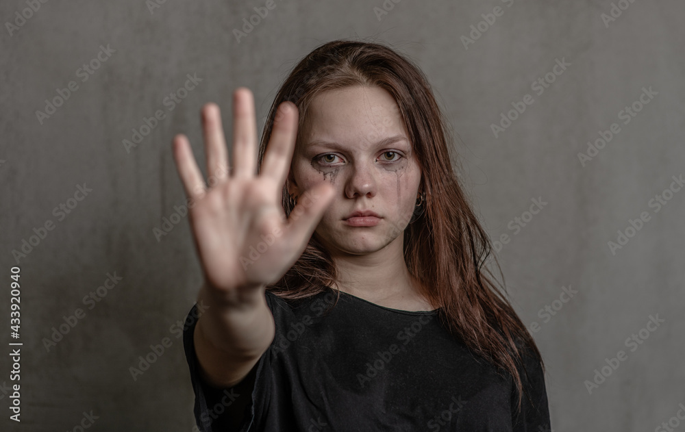 Unhappy teenage girl shows a stop sign with her hand Unhappy teenage girl shows a stop sign with her hand