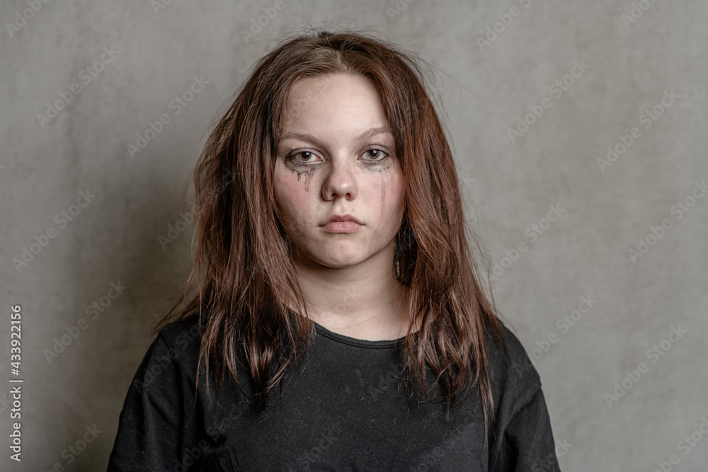 Portrait of a sad teenager on grey background Portrait of a sad teenager on grey background