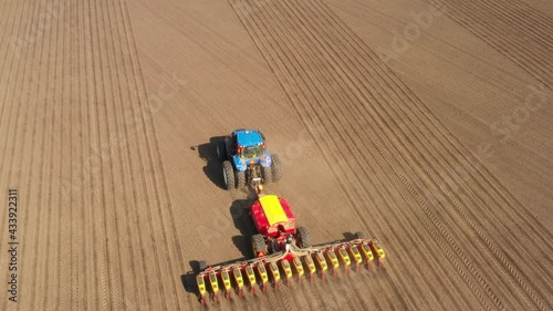 Tractor with seeder in the field, aerial view.