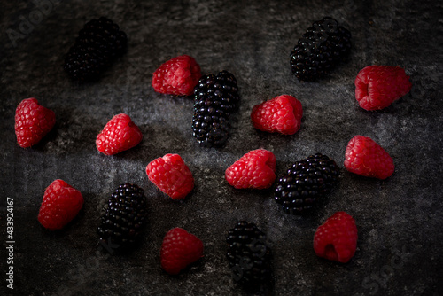 raspberries and blackberries on dark gray background, low key studio 