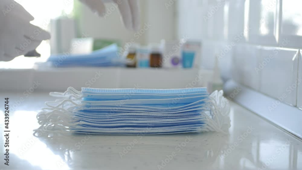 Pharmacist Checking a Package of Protective Face Masks Uses in Medical Purposes Against Coronavirus Infection Spread. Pharmacist Checking a Package of Protective Face Masks Uses in Medical Purposes Against Coronavirus Infection Spread.