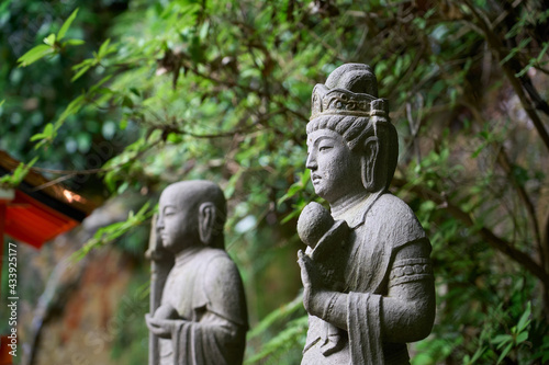 Two Buddha statues standing in the forest