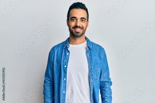 Young hispanic man wearing casual clothes with a happy and cool smile on face. lucky person.