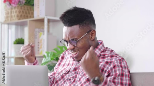 Serious African man having a video conference with team on laptop, and Getting angry with other because of there are a person in team making a big mistake, black man sitting on a sofa