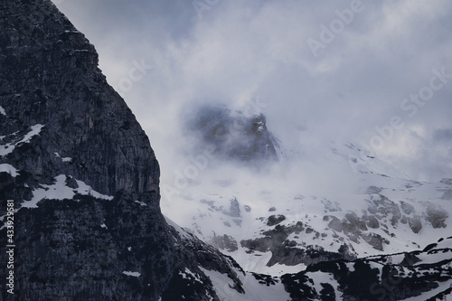 Dark mood - dramatic clouds and fogs over the mountains and parts with snow © Hanjin