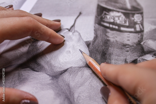 Hands drawing a sketch with pencil top view