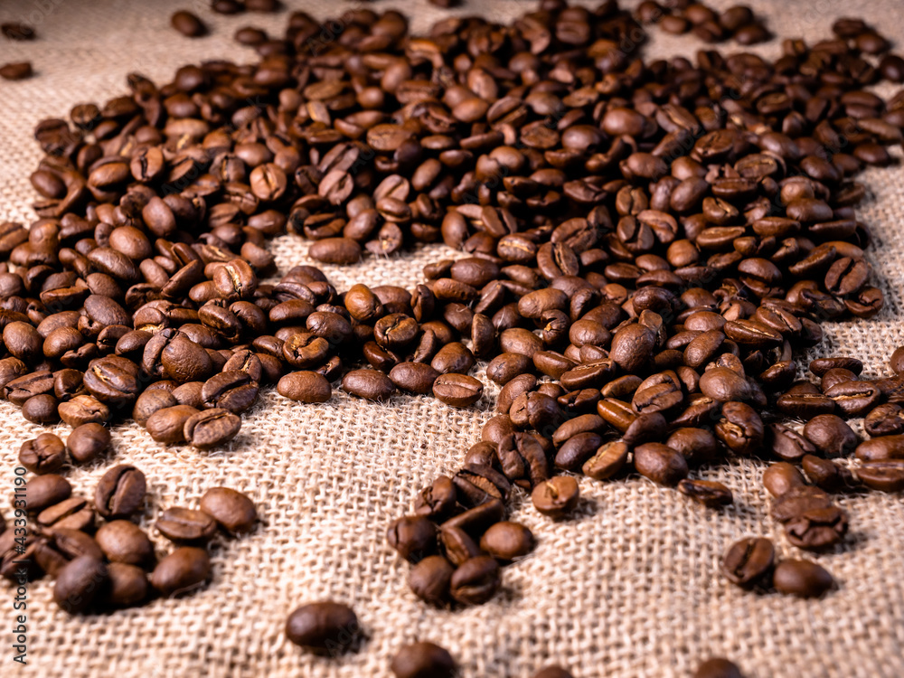 Roasted coffee beans background. Arabica beans on a jute bag. Macro texture of jute cloth with coffe beans on it. Roasted coffee beans background. Arabica beans on a jute bag. Macro texture of jute cloth with coffe beans on it.
