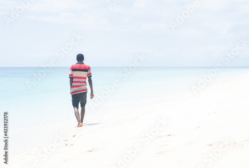 Black African young man walking on the beach
