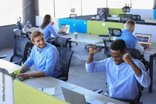 Businessman with arms raised celebrating success recived good news on e-mail in office. photo