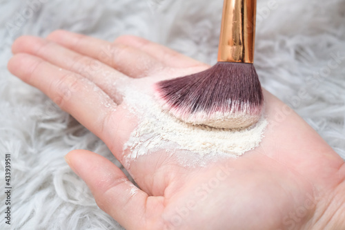 Bilde på lerret Close up woman holding talc make up and brush on carpet background, beauty concept