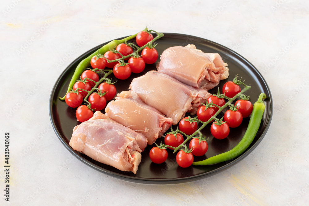 Raw boneless chicken thigh on a white wooden background. Chicken Meat background. Raw boneless chicken thigh on a white wooden background. Chicken Meat background.