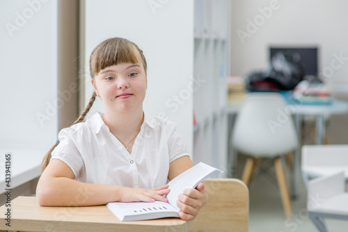 Portrait of a girl with syndrome down at a school.  Education for disabled children concept. Empty space for text