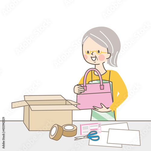 商品を包んで送るシニア女性