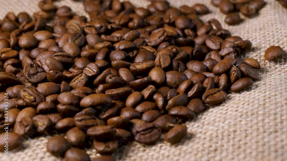 Roasted coffee beans. Smooth motion of arabica coffee seeds. Fragrant coffee beans scrolls slowly around the camera. Slow Motion Close Up of Whole Roasted Robusta Beans Roasted coffee beans. Smooth motion of arabica coffee seeds. Fragrant coffee beans scrolls slowly around the camera. Slow Motion Close Up of Whole Roasted Robusta Beans