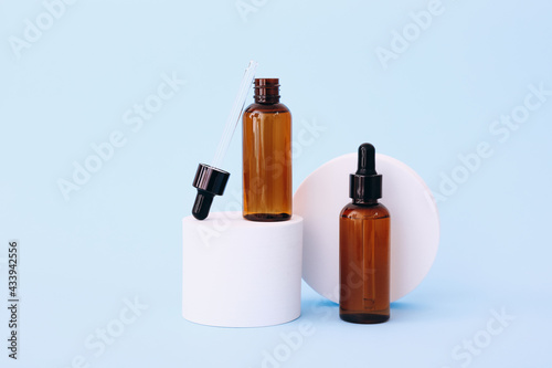 Trendy background with natural cosmetic skincare bottles on blue background. Product presentation.
