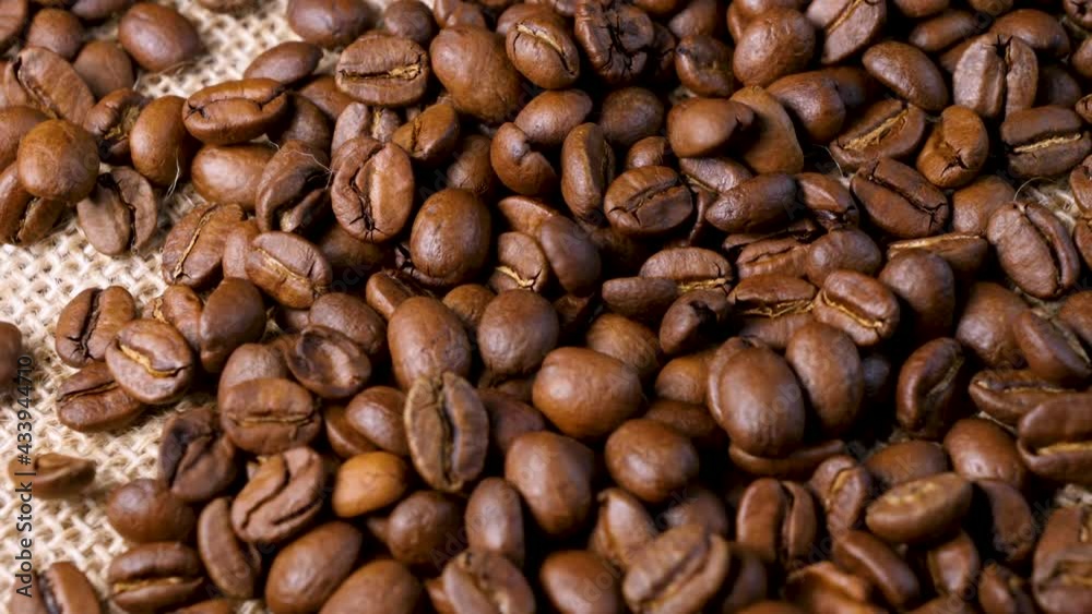 Roasted coffee beans. Smooth motion of arabica coffee seeds. Fragrant coffee beans scrolls slowly around the camera. Slow Motion Close Up of Whole Roasted Robusta Beans Roasted coffee beans. Smooth motion of arabica coffee seeds. Fragrant coffee beans scrolls slowly around the camera. Slow Motion Close Up of Whole Roasted Robusta Beans