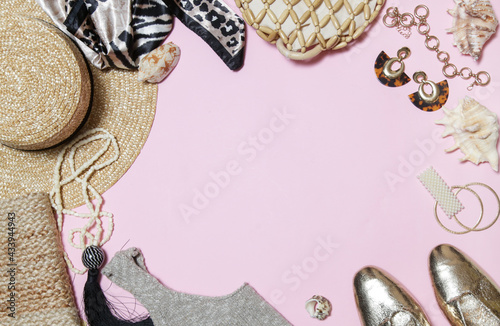 Summer fashionable accessories in golden tones on pink background with copy space. Women's items for summer season.