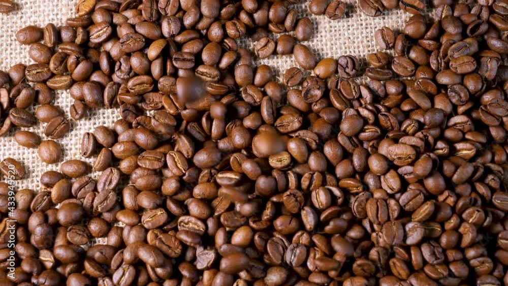 Roasted coffee beans. Smooth motion of arabica coffee seeds. Fragrant coffee beans scrolls slowly around the camera. Slow Motion Close Up of Whole Roasted Robusta Beans Roasted coffee beans. Smooth motion of arabica coffee seeds. Fragrant coffee beans scrolls slowly around the camera. Slow Motion Close Up of Whole Roasted Robusta Beans