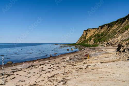 Fototapeta Naklejka Na Ścianę i Meble -  The Baltic Sea coast with an empty plastic chair on the beach and the cliffs of Boltenhagen, Mecklenburg-Western Pomerania, Germany