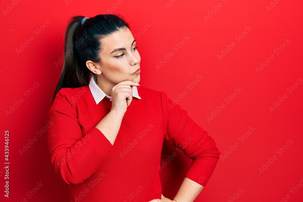 Young hispanic woman wearing casual clothes serious face thinking about question with hand on chin, thoughtful about confusing idea Young hispanic woman wearing casual clothes serious face thinking about question with hand on chin, thoughtful about confusing idea