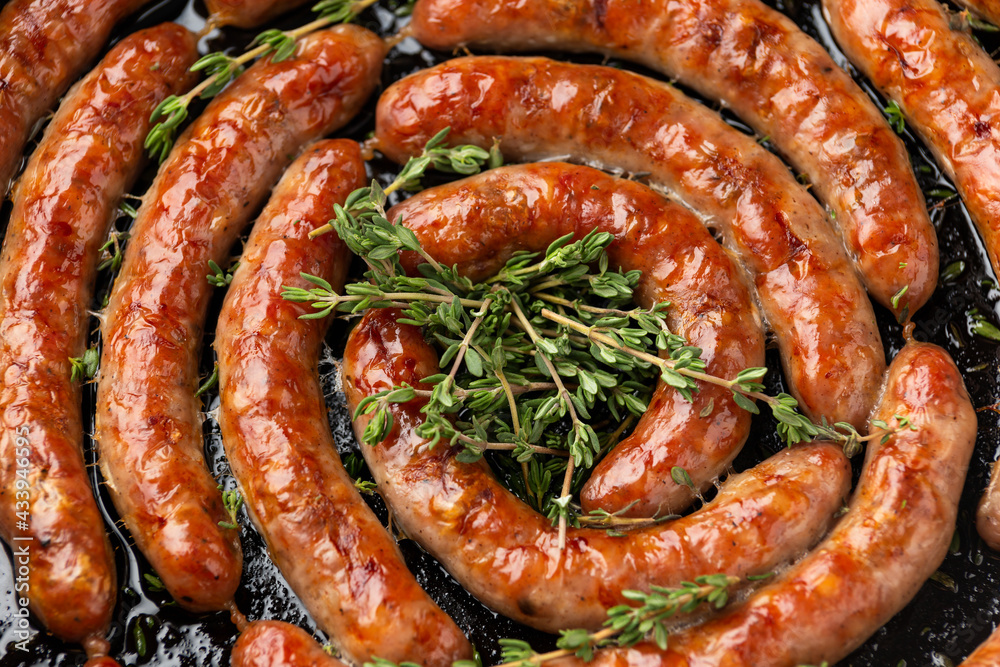 Homemade Pork Sausages in rustic pan with thyme Homemade Pork Sausages in rustic pan with thyme