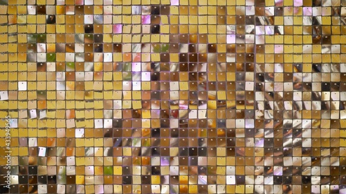 Background of many small cubes, cells of golden shiny color. Beautiful shiny iridescent background of golden color.