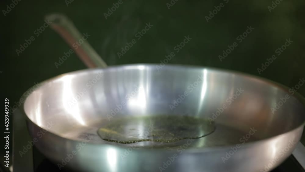 The cook pours oil into a hot frying pan, frying potatoes The cook pours oil into a hot frying pan, frying potatoes