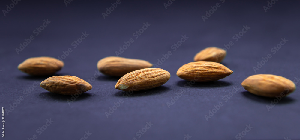 Obraz premium Almonds closeup isolated in blue backround.