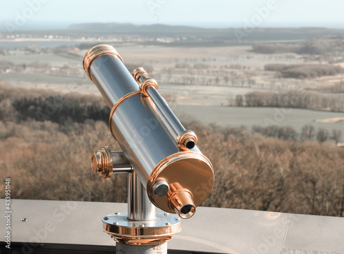 Monocular telescope at sunset with a cloudy sky photo
