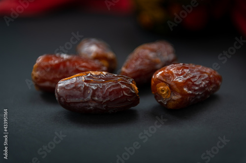 Sweet soft moist natural dates ioslated with a dark background.