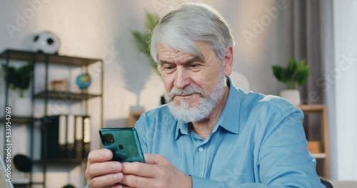 Wallpaper Mural Portrait of handsome aged man using smartphone at home Torontodigital.ca