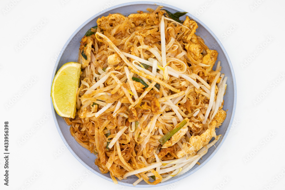 Delicious Pad Thai with a Lime on a Blue Plate with a White Background
