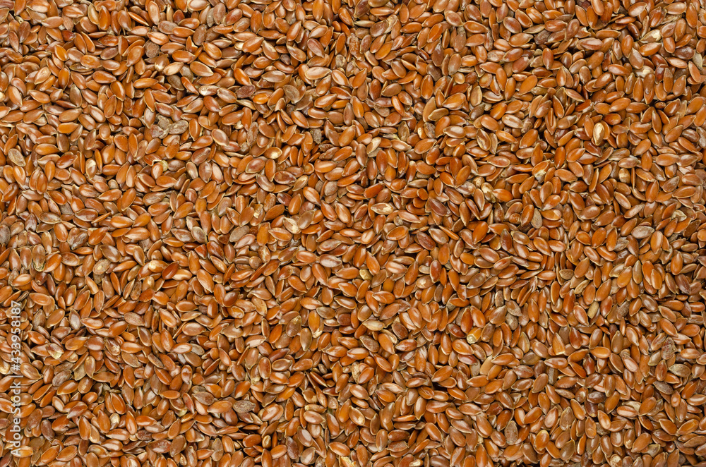 Brown flaxseeds, background, from above. Whole raw linseed, fruits of Linum usitatissimum, rich in omega-3 fatty acids. A nutritional supplement or turned into linseed oil. Backdrop. Macro food photo. Brown flaxseeds, background, from above. Whole raw linseed, fruits of Linum usitatissimum, rich in omega-3 fatty acids. A nutritional supplement or turned into linseed oil. Backdrop. Macro food photo.