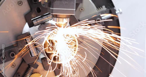 Automated programmed machine for metal processing. Industrial laser machine cuts out parts in sheet steel. Heat. Sparks during operation of production machine at factory.