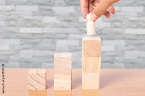 Hand chooses people standing with stacking wooden blocks. development concept.