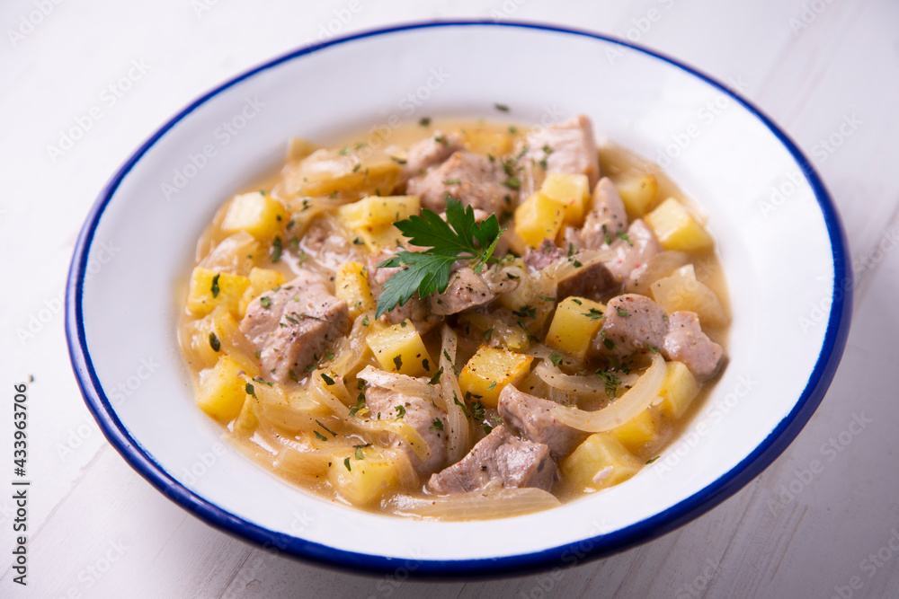 Pork cooked with potatoes and onion