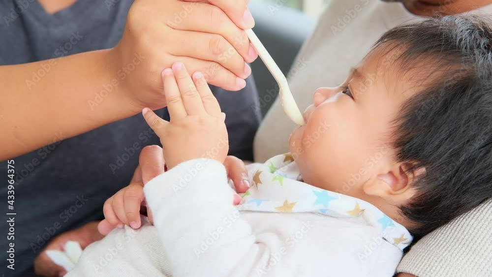 Close up portrait of asian family enjoy giving food to newborn baby son. Baby care, family day concept. Close up portrait of asian family enjoy giving food to newborn baby son. Baby care, family day concept.