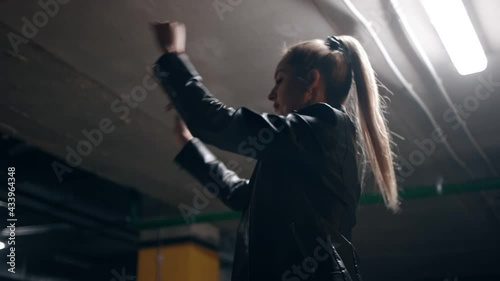 An imperturbable girl straightens her hair in a parking