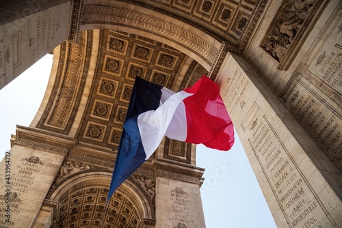 Fototapeta Naklejka Na Ścianę i Meble -  French flag waving under Arc de Triomphe in honor of VE day. Paris, France.	
