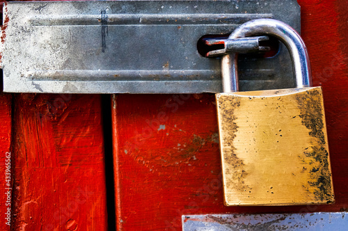 Quadro em tela Brass old padlock keeping a red painted door locked