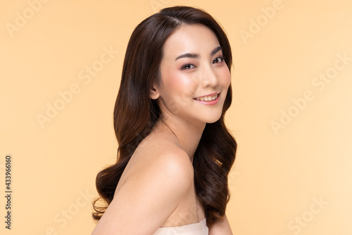 Wellness Asian young woman looking at camera clean fresh and nutural pure skin,Pretty girl smile with be moist skin on her face shining like a model,Facial treatment of beauty woman,isolated on Beige