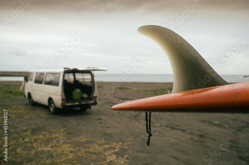 Van and surf board at a beach
