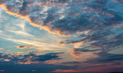 Dramatic evening sky with blue, white and orange clouds