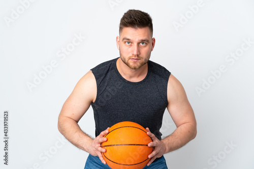 Russian handsome man isolated on white background playing basketball