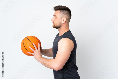 Russian handsome man isolated on white background playing basketball
