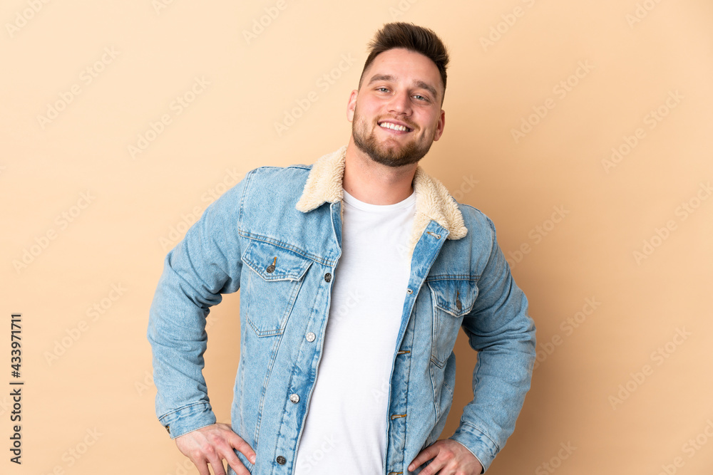 Russian handsome man over isolated background posing with arms at hip and smiling Russian handsome man over isolated background posing with arms at hip and smiling