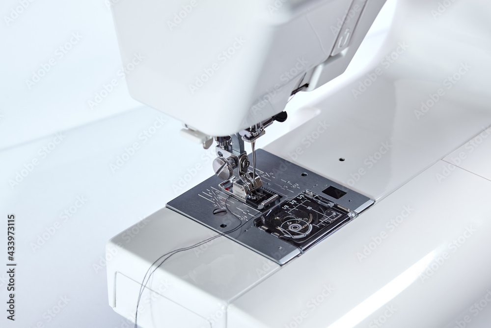 Sewing machine working part, replacement foot. Sewing machine with thread, closeup